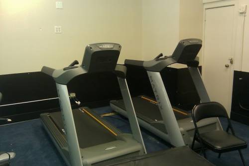 Two Precor treadmills and a chair in a gym