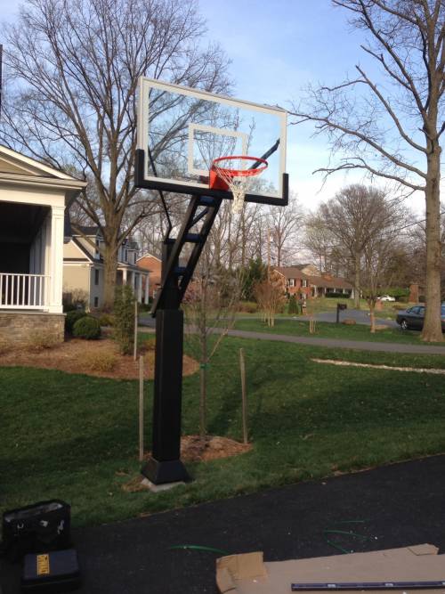 A basketball hoop in a driveway in front of a house
