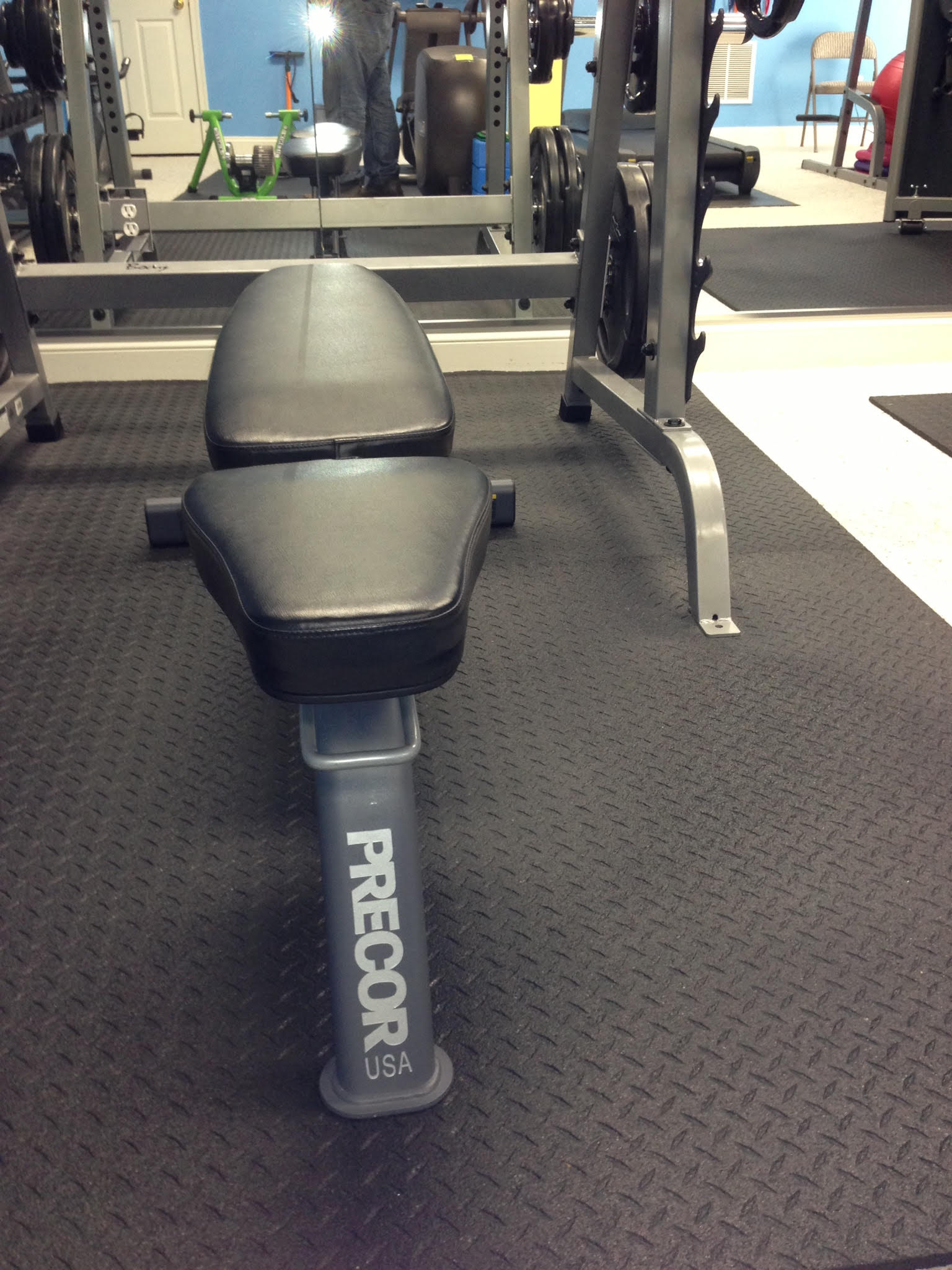 A bench in a gym that says precor on it