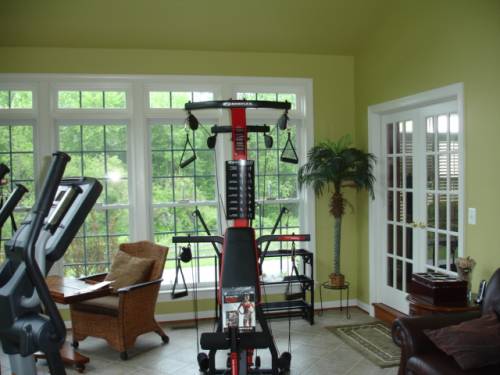A room with a lot of windows and exercise equipment