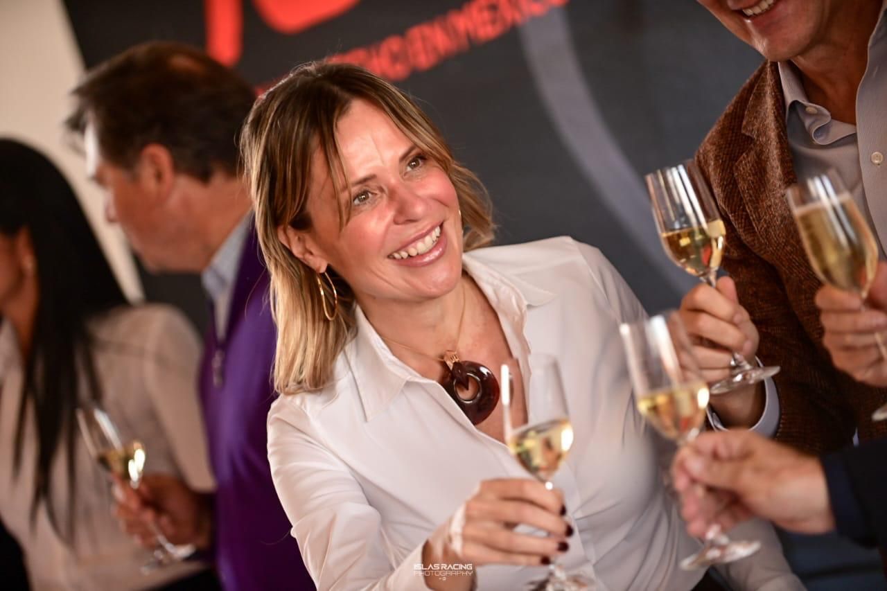 Una mujer sonríe mientras sostiene una copa de champán.