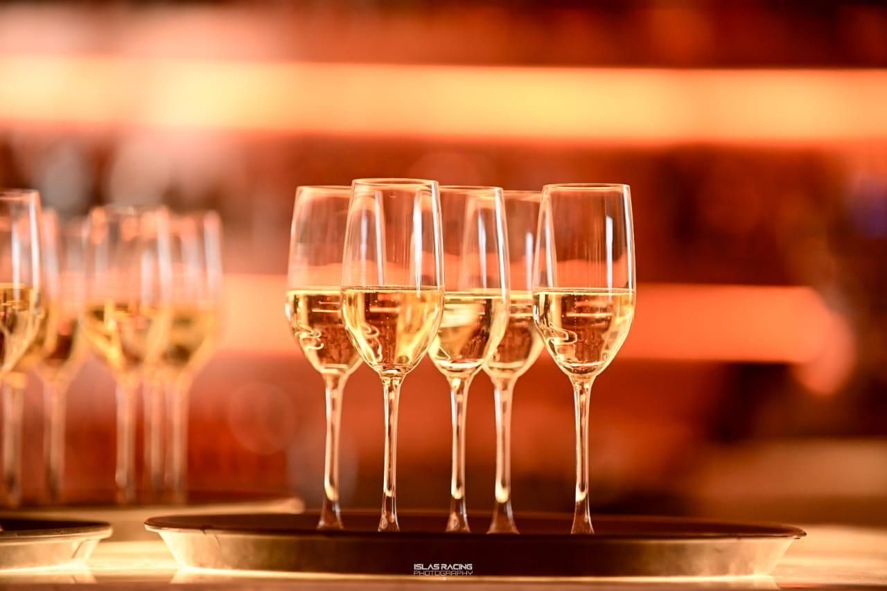 Cuatro copas de vino están alineadas en una bandeja sobre una mesa.