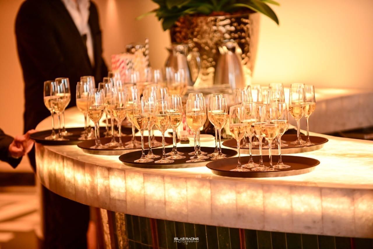 Un camarero sirve copas de champán en bandejas en un bar.