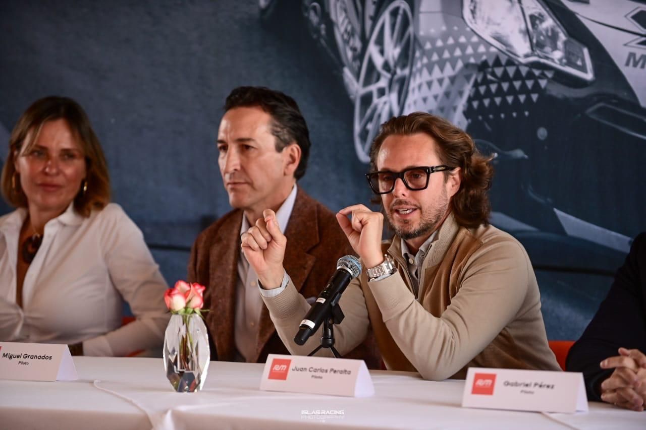 Un grupo de personas está sentada en una mesa con un micrófono.