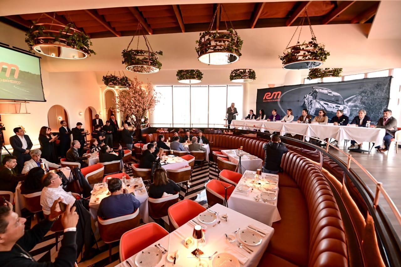 Un grupo de personas están sentadas en las mesas de un restaurante.