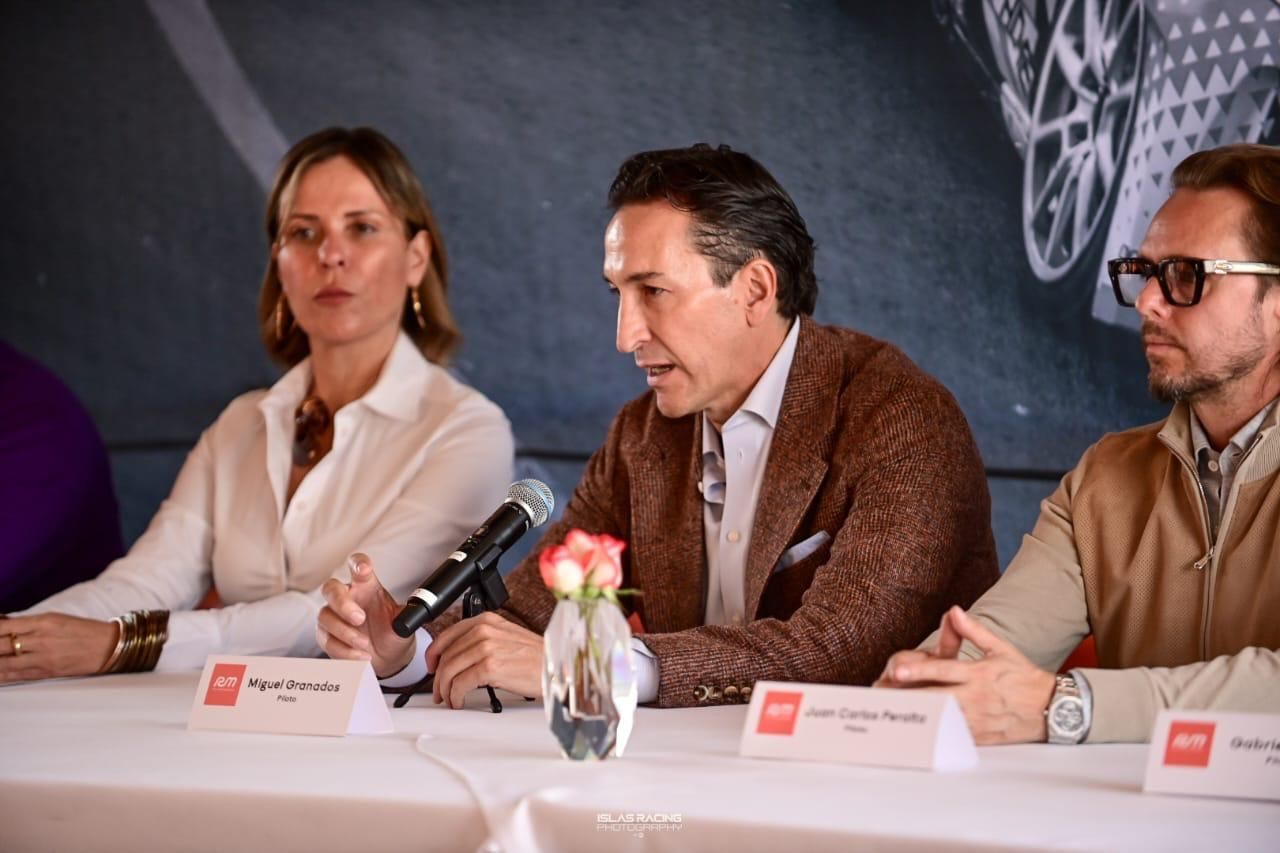 Un grupo de personas están sentadas en una mesa con micrófonos.