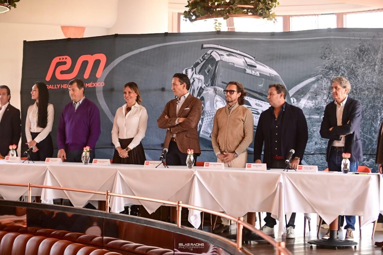 Un grupo de personas están sentadas en mesas frente a un gran cartel que dice rem