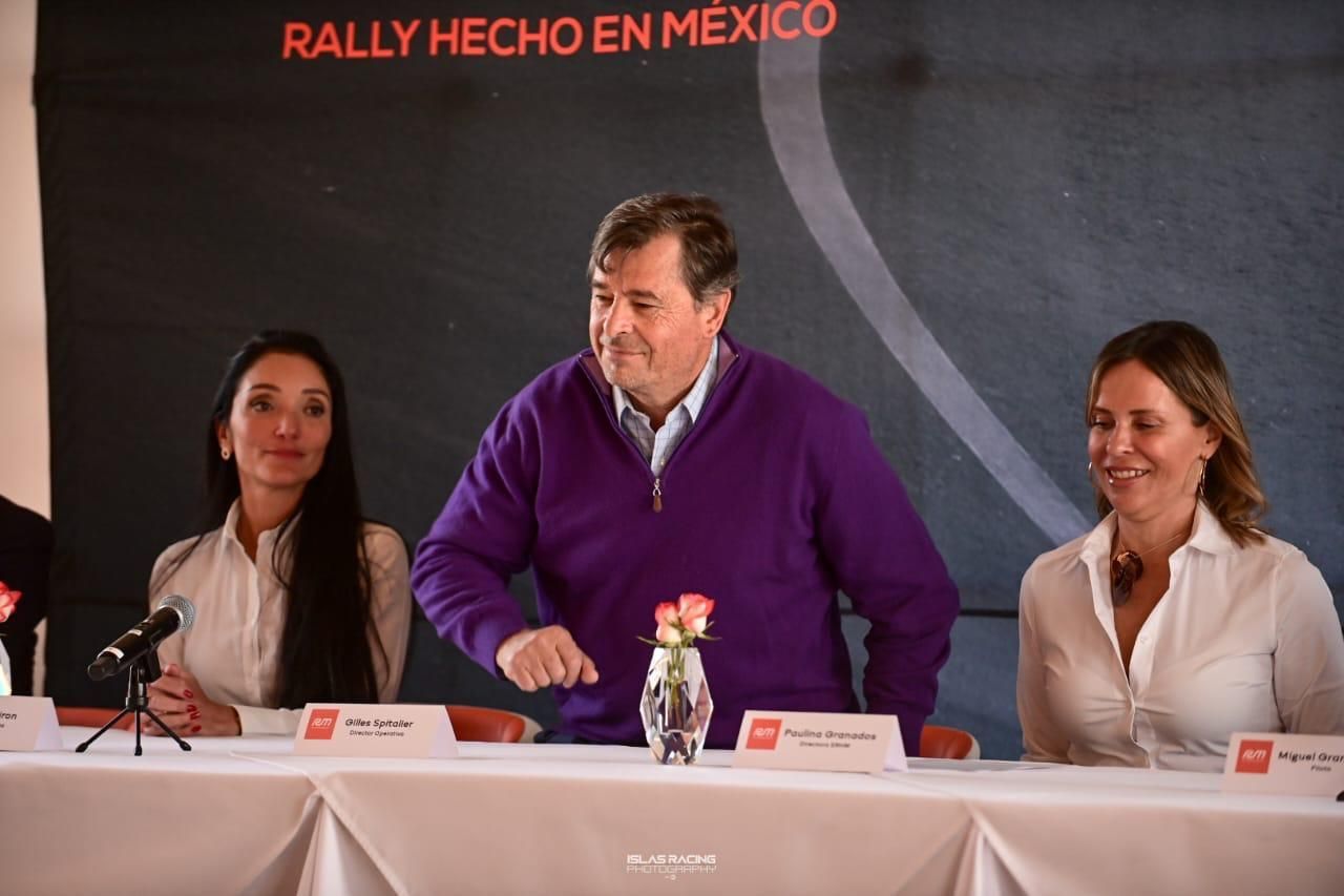 Un hombre con un suéter morado está sentado en una mesa con dos mujeres.