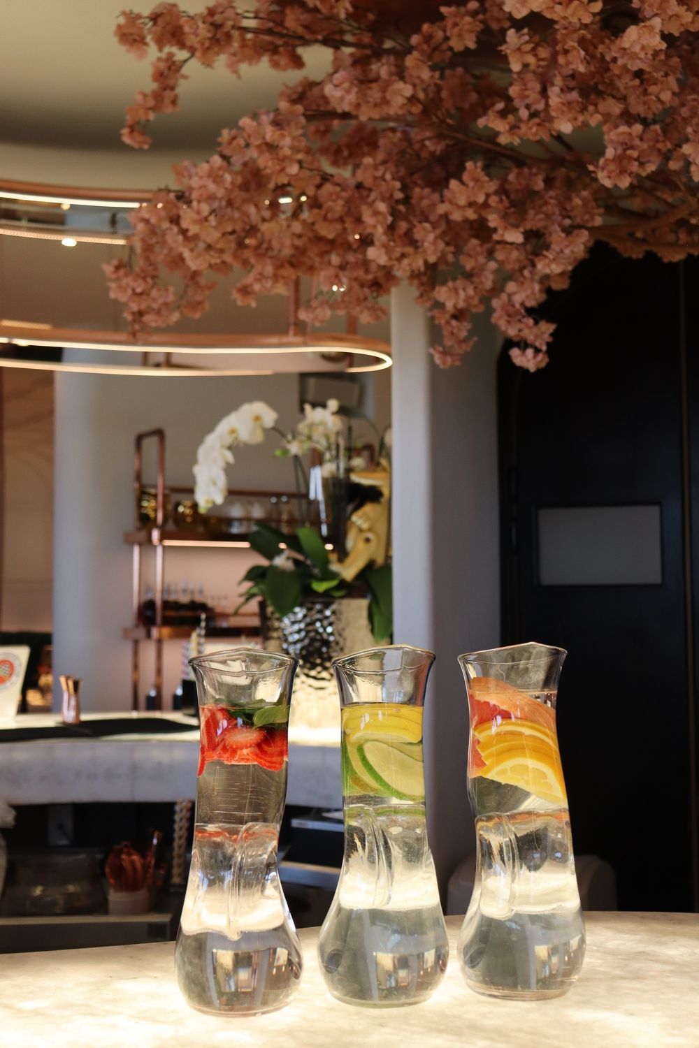 Hay tres jarras de agua sobre un mostrador en una habitación.