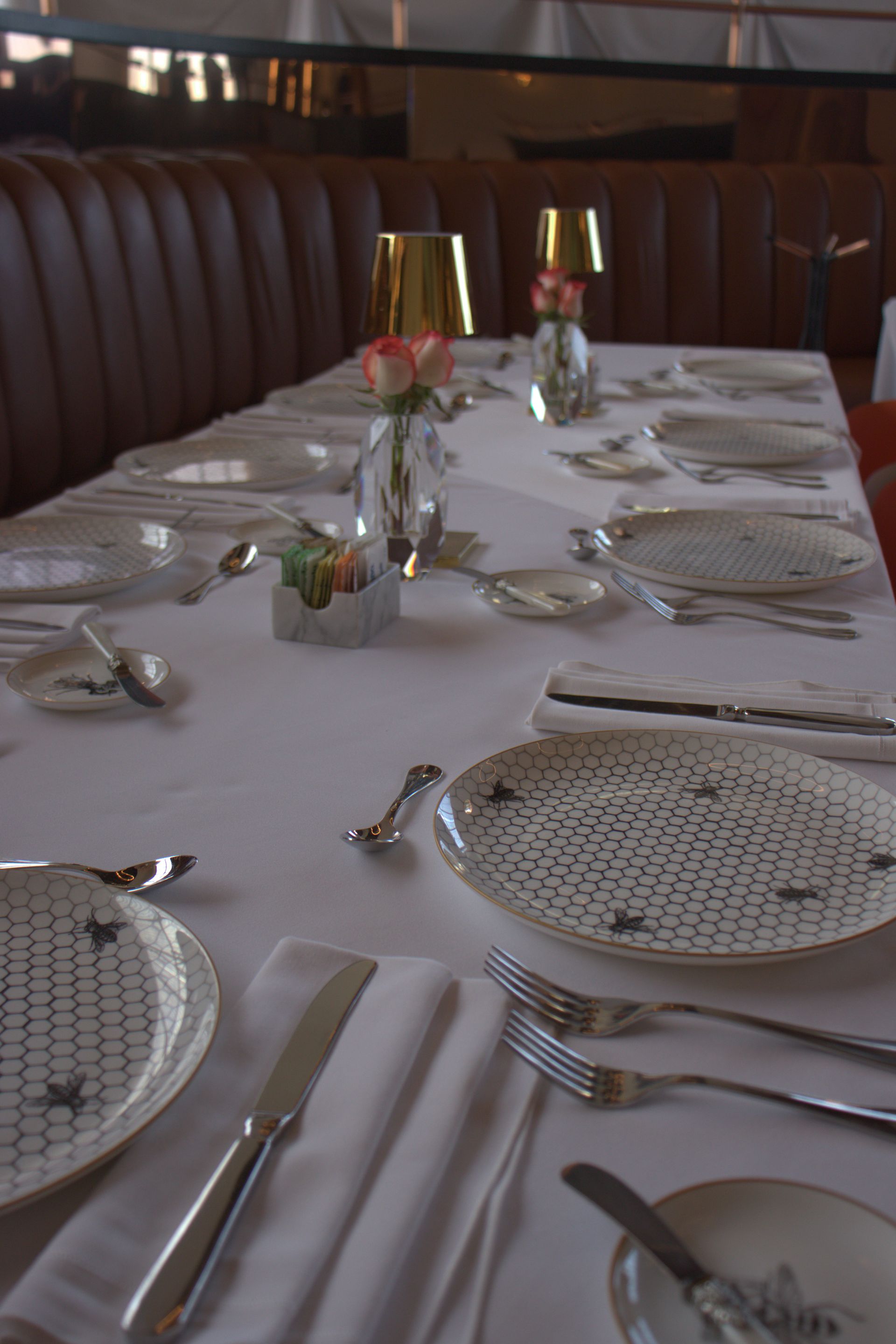 Una mesa larga con platos y cubiertos sobre ella.