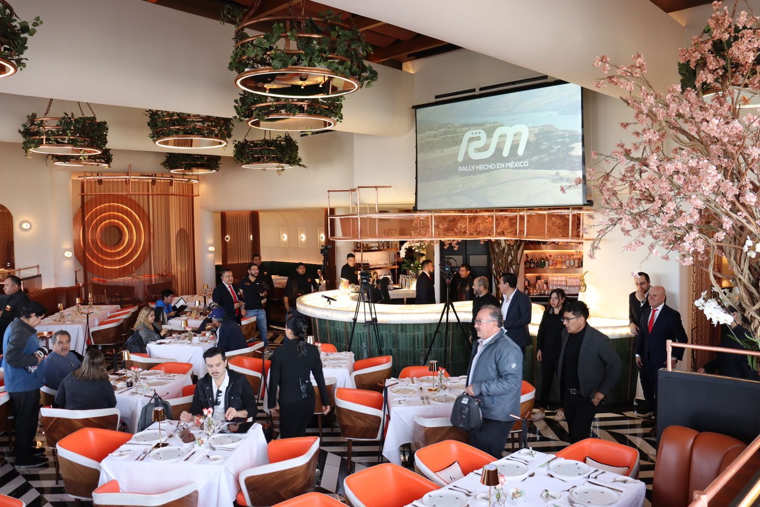 Una sala grande con mesas y sillas y una pantalla grande con la palabra rem en ella.