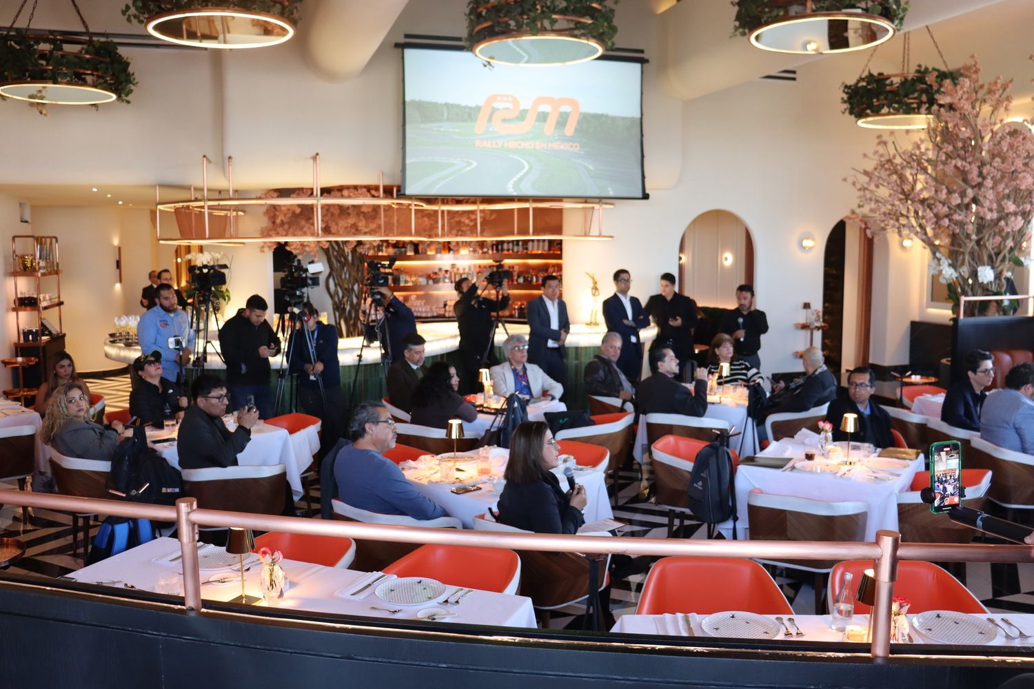 Un grupo de personas están sentadas en las mesas de un restaurante.