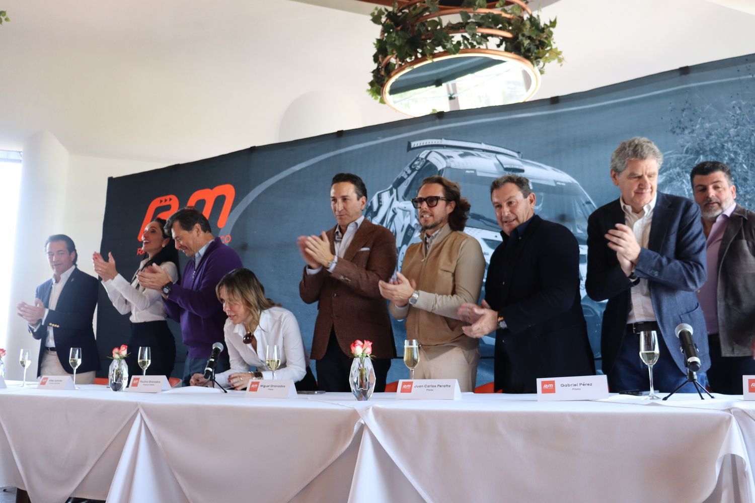 Un grupo de personas están de pie alrededor de una mesa aplaudiendo.