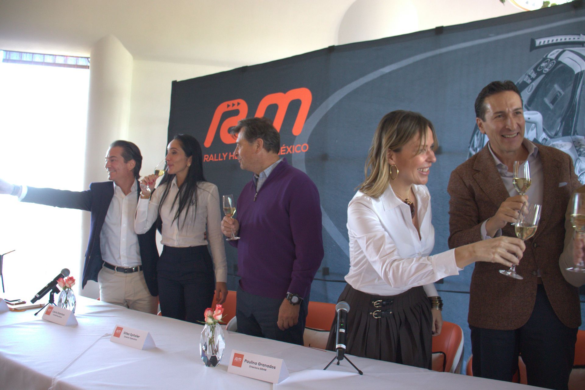 Un grupo de personas están de pie alrededor de una mesa sosteniendo copas de champán.