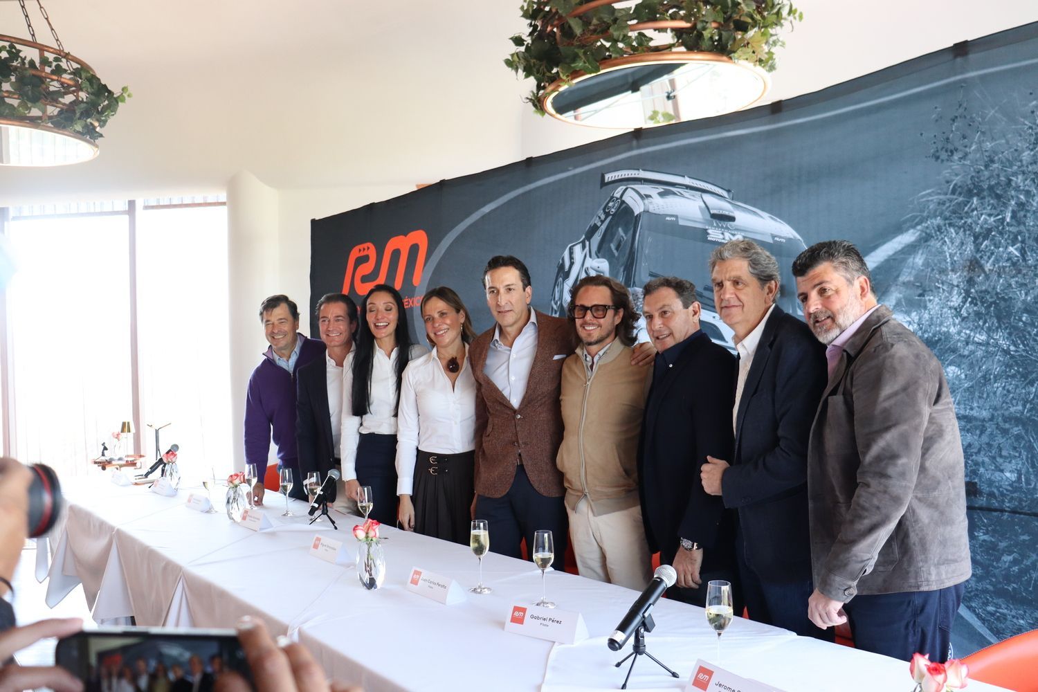 Un grupo de personas posan para una fotografía frente a una mesa larga.