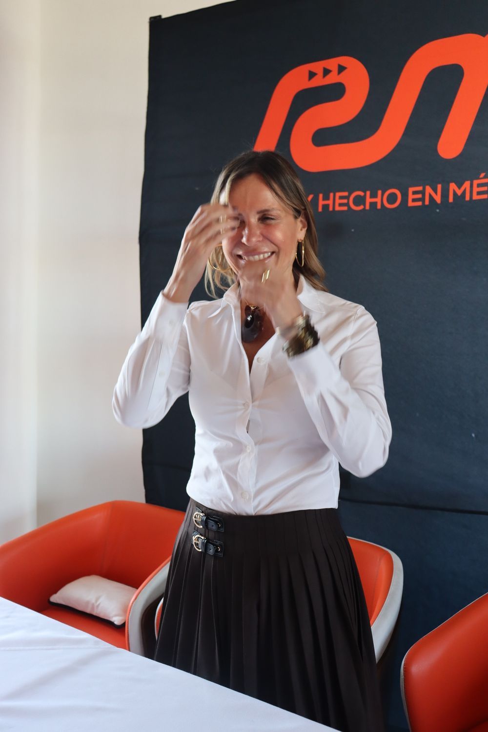 Una mujer se encuentra frente a un cartel que dice hecho en mí