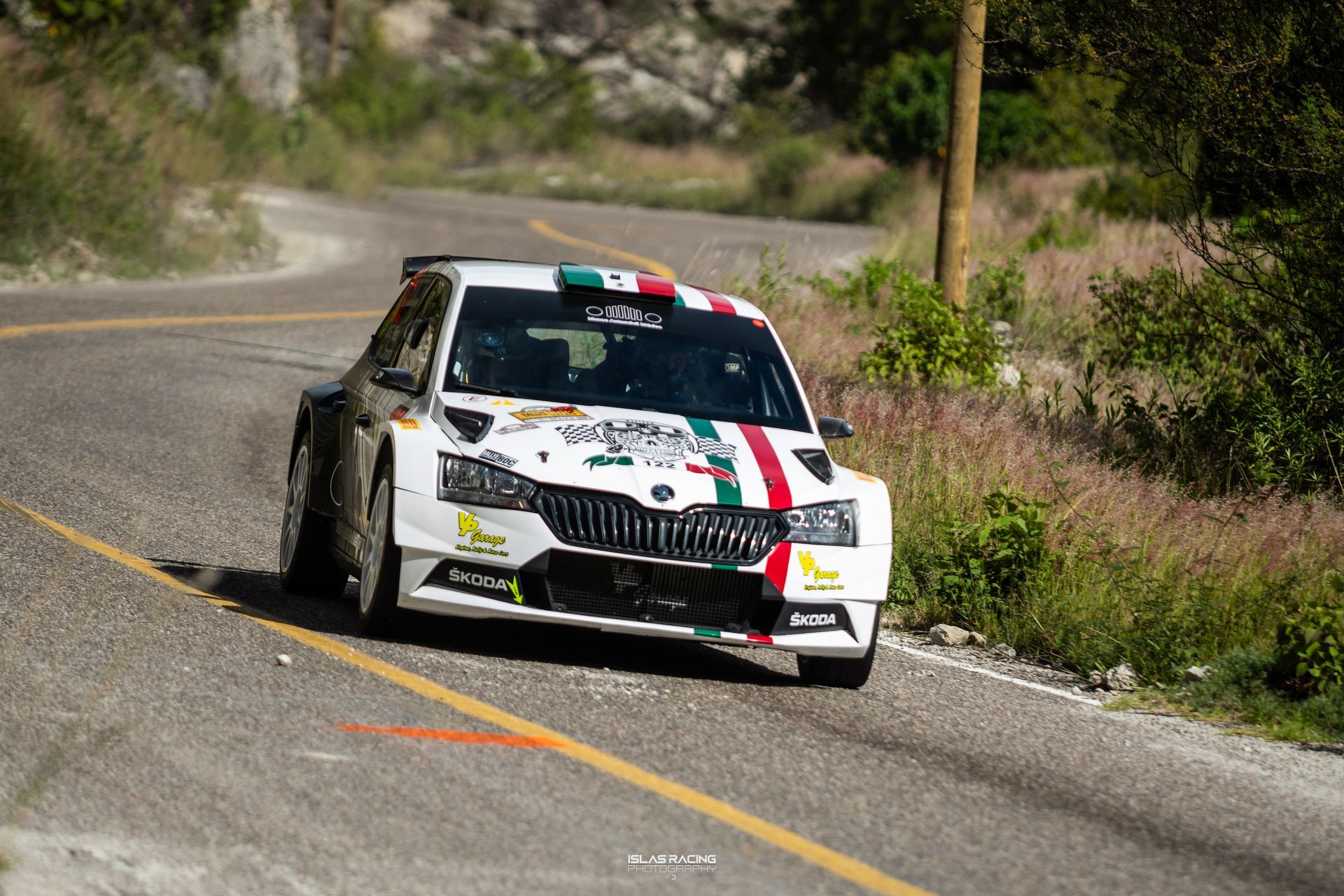 Un coche de carreras blanco circula por una carretera.