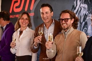 Un grupo de personas están de pie una al lado de la otra sosteniendo copas de champán.