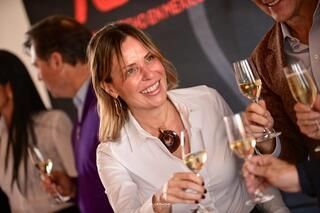 Una mujer sonríe mientras sostiene una copa de champán.