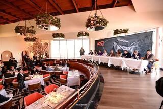 Un grupo de personas están sentadas en las mesas de un restaurante.