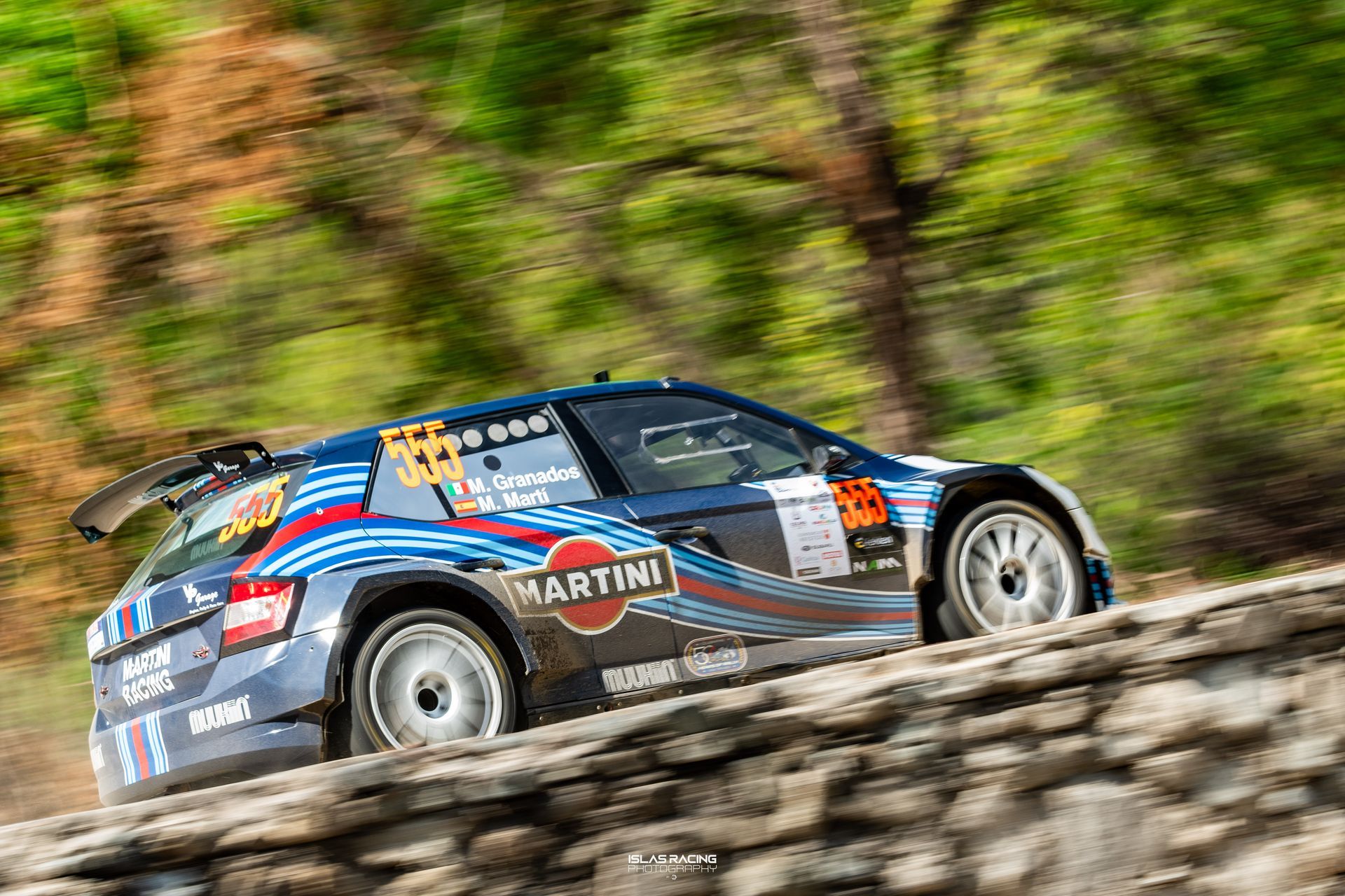 Un coche de rally desciende por una colina rocosa.