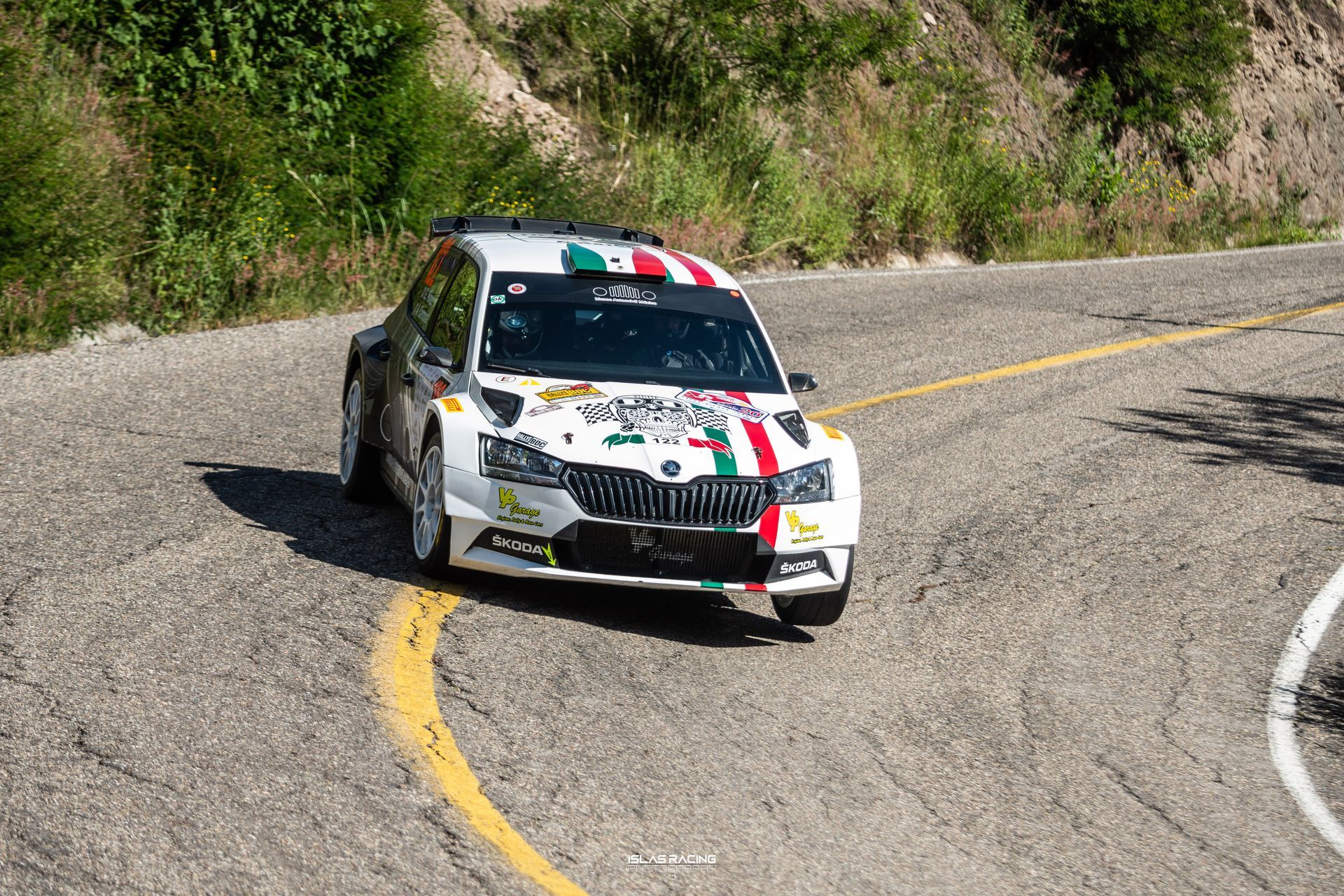 Un coche de carreras blanco y rojo circula por una carretera con curvas.
