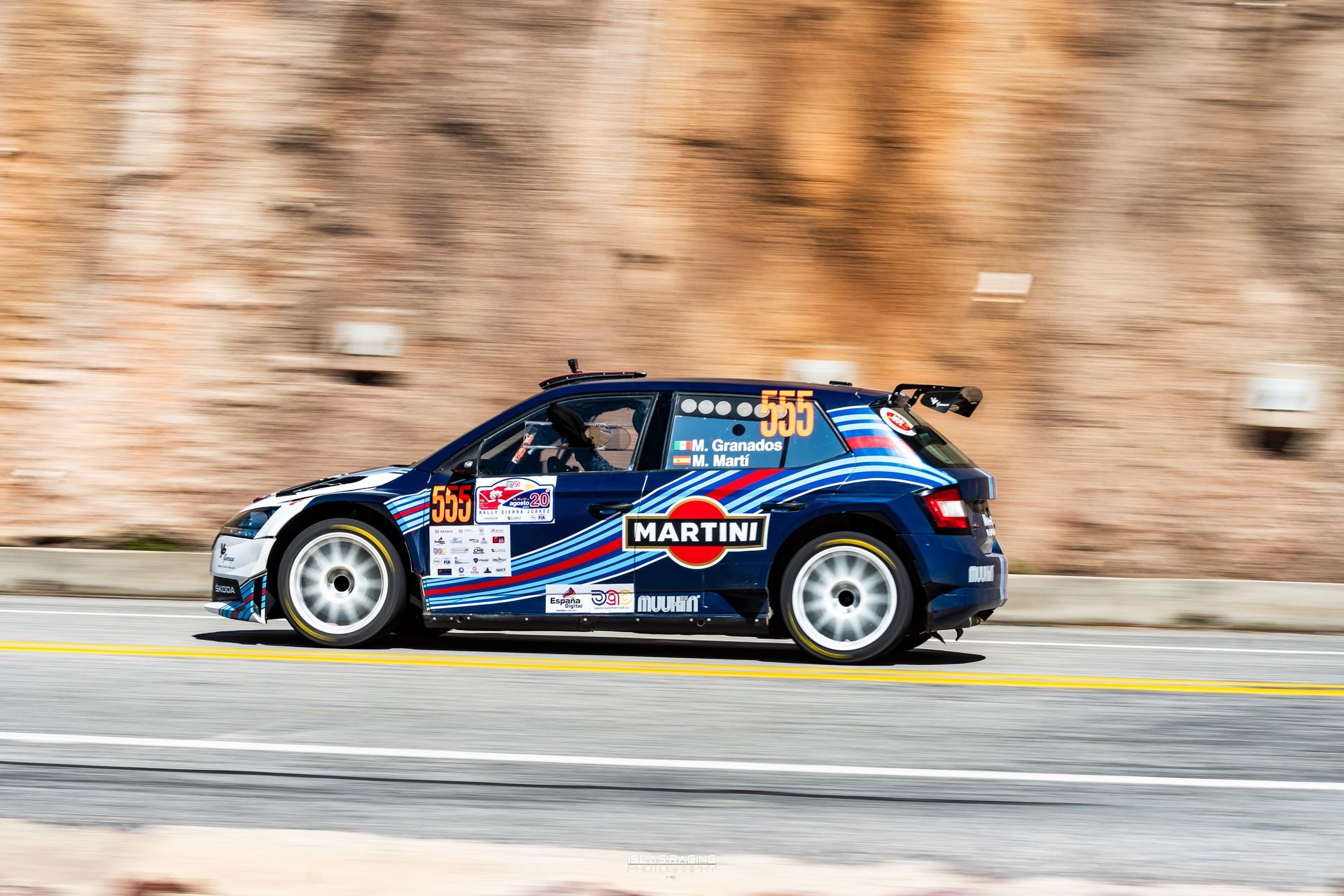 Un coche de rally Blue Martini circula por una carretera.