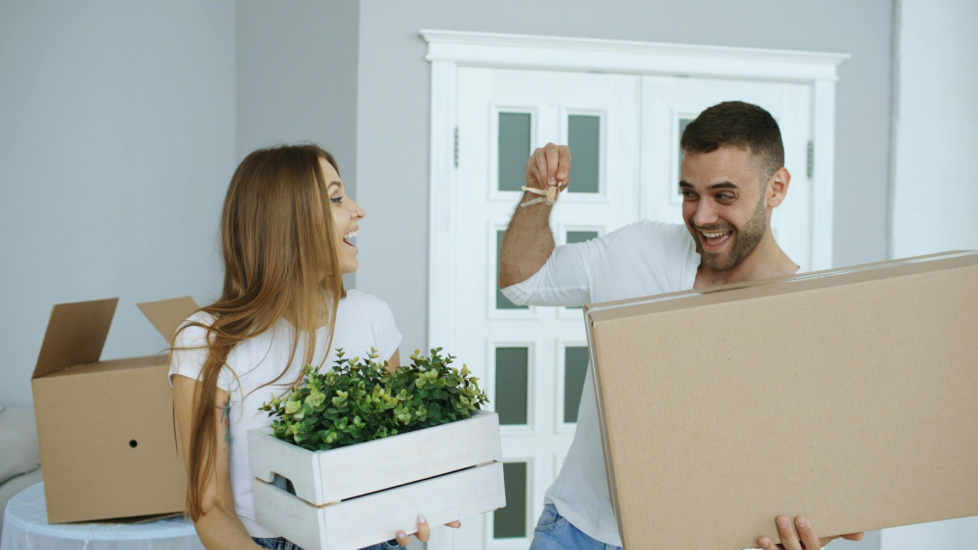 a happy couple holding a planter and box