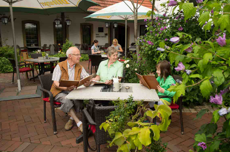 Zwei Senioren sitzen im Außenbereich vom Restaurant vom Hotel „Haus Große Kettler“