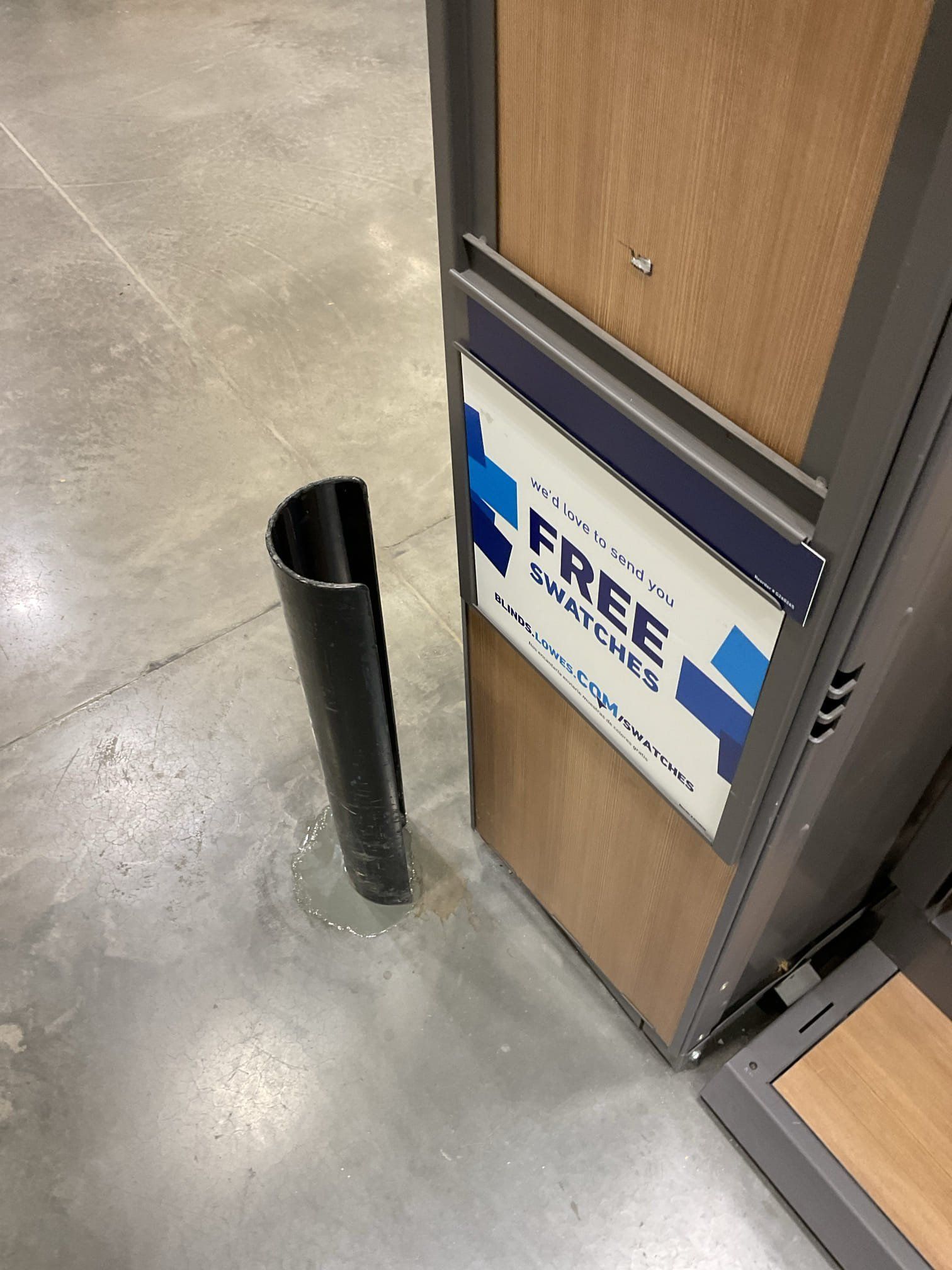 Black metal guard next to store display, with sign offering 