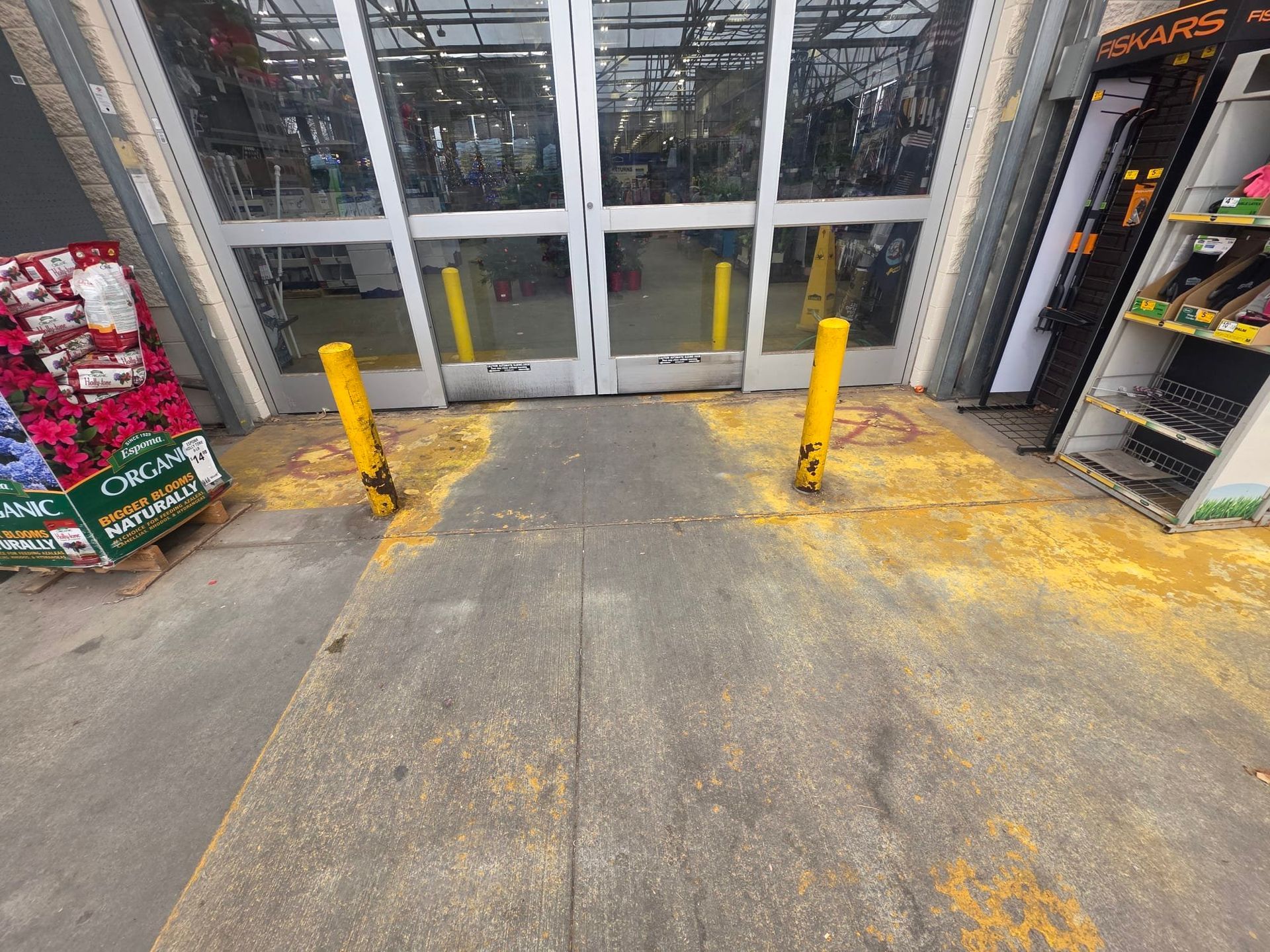 Concrete and brick retaining wall next to shopping carts and plants.