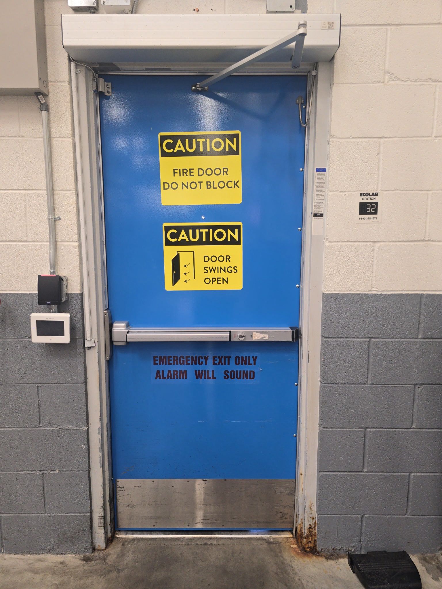 Concrete and brick retaining wall next to shopping carts and plants.