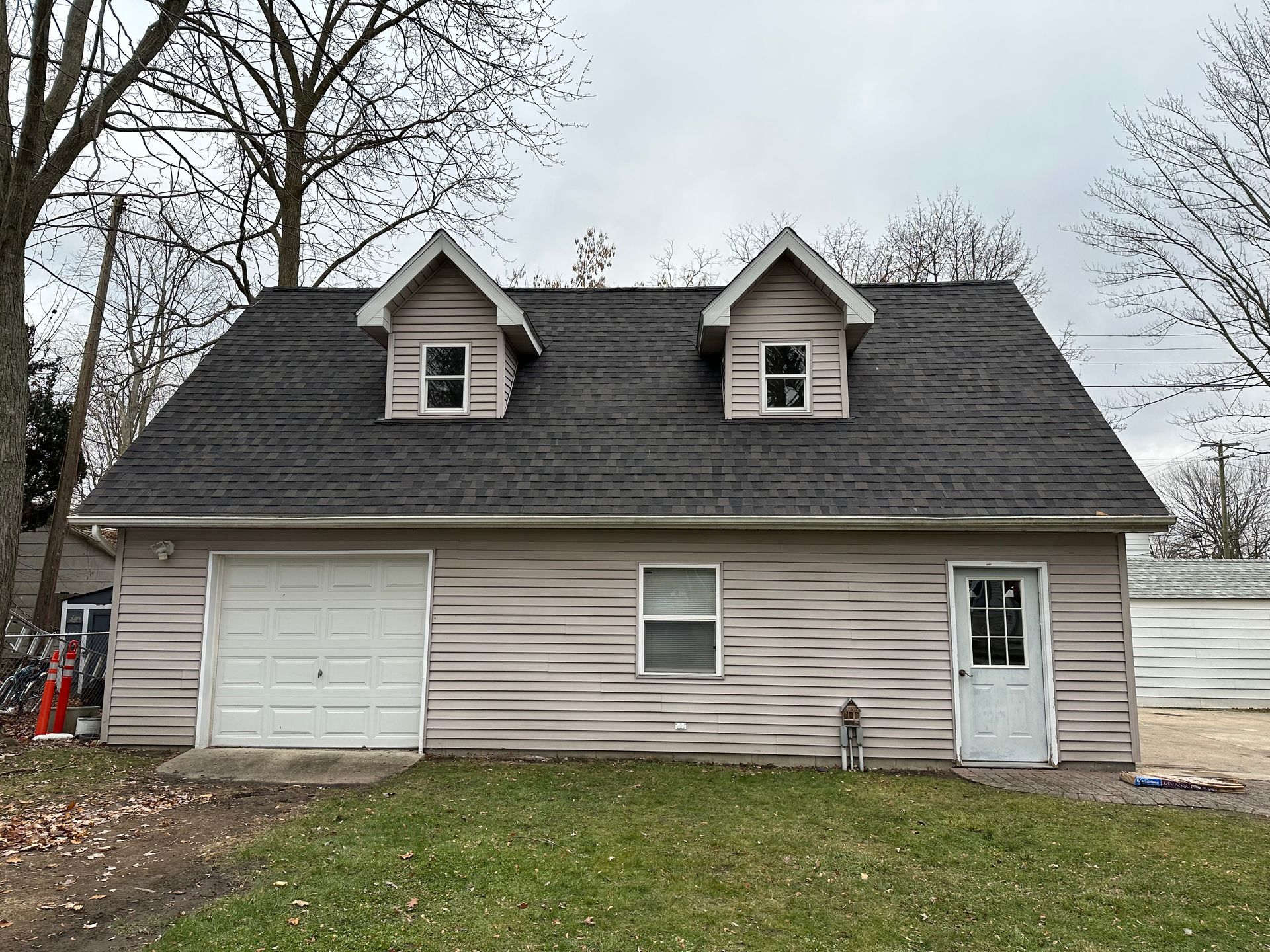 A house with a garage and a black roof.