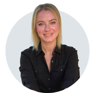 A blonde woman, smiling, in a black collared shirt.