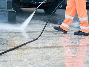 Concrete Driveways — Man Cleaning the Walkways in Myers, FL Concrete Driveways — Man Cleaning the Walkways in Myers, FL