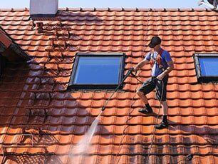 Roofing — Man Cleaning The Roof in Myers, FL