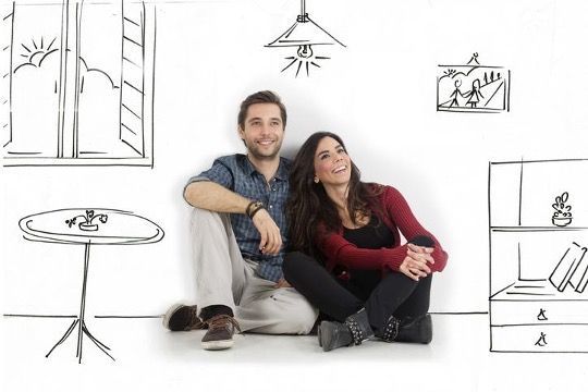 Smiling couple sitting in a drawn room