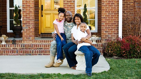 Military family in front of house