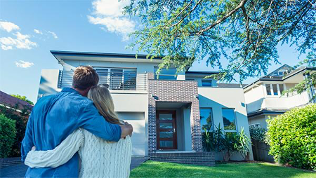 Hugging couple looking at new home