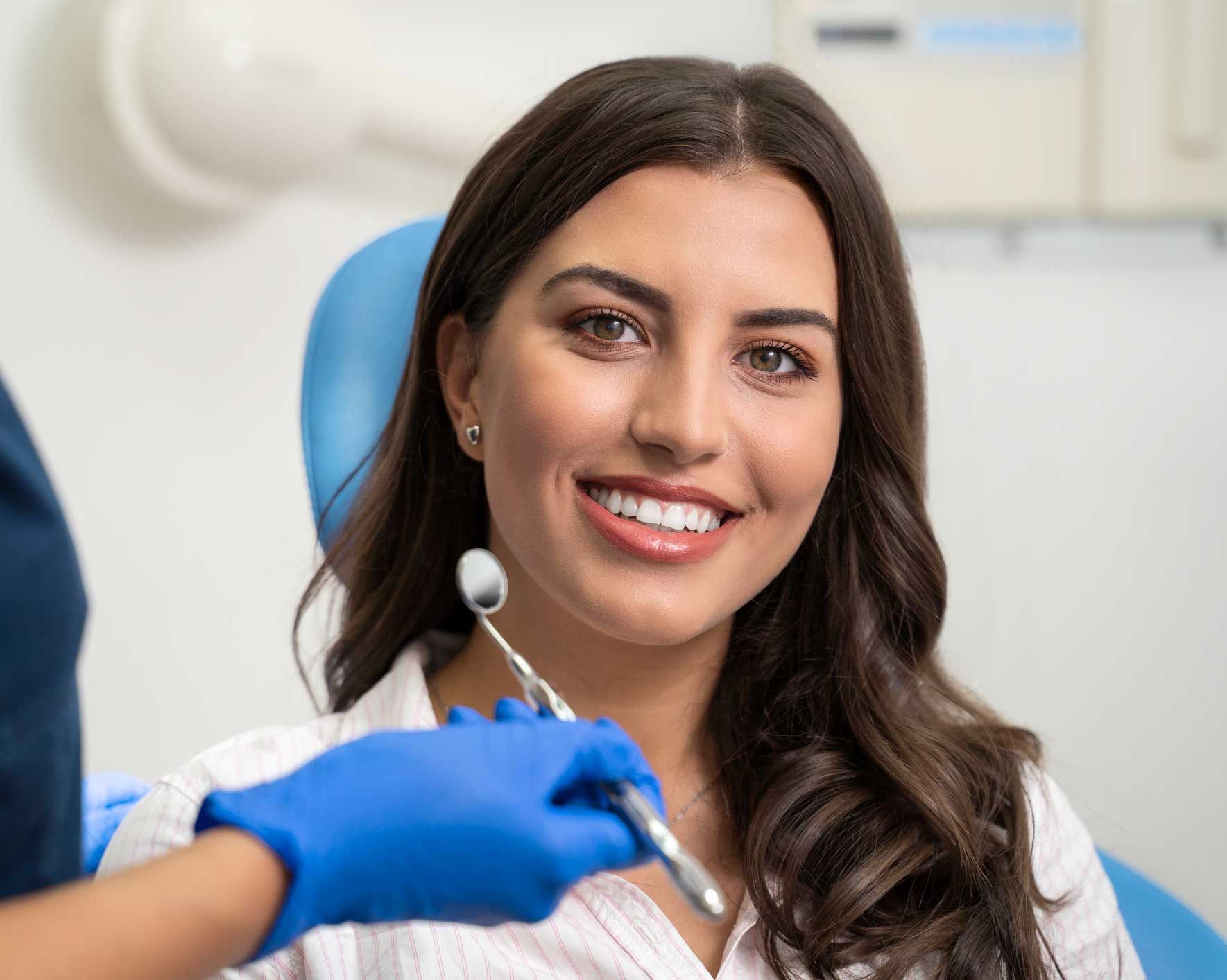 Young woman with a beautiful smile, showcasing general dentist services at dental office.