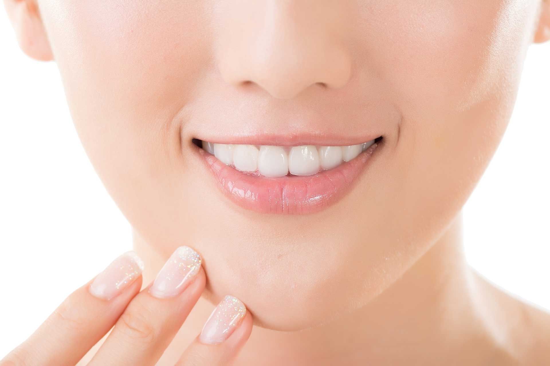 Close-up of a smiling woman showcasing healthy teeth, representing a general dentist's care. Close-up of a smiling woman showcasing healthy teeth, representing a general dentist's care.