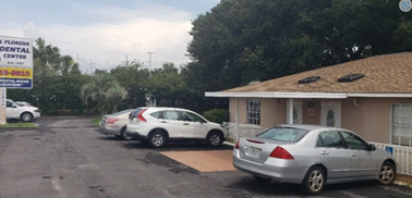 Exterior and front of Central Florida Dental, with two cars parked on its front.