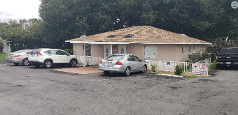 Front of Central Florida Dental, with three cars parked in front of the building and its white fence.