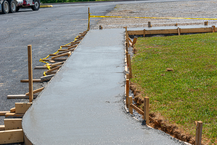 freshly poured concrete sidewalk with the lawn