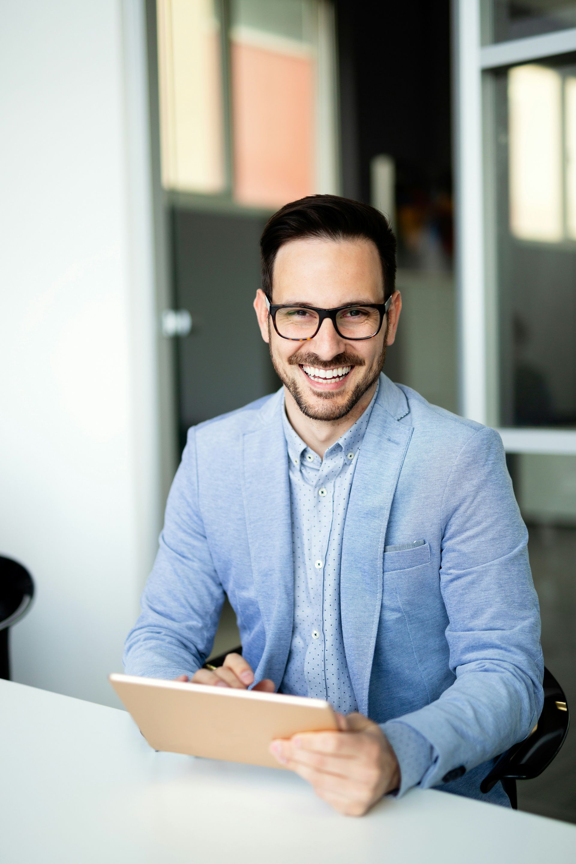 A man in a blue shirt and tie is using a laptop computer.