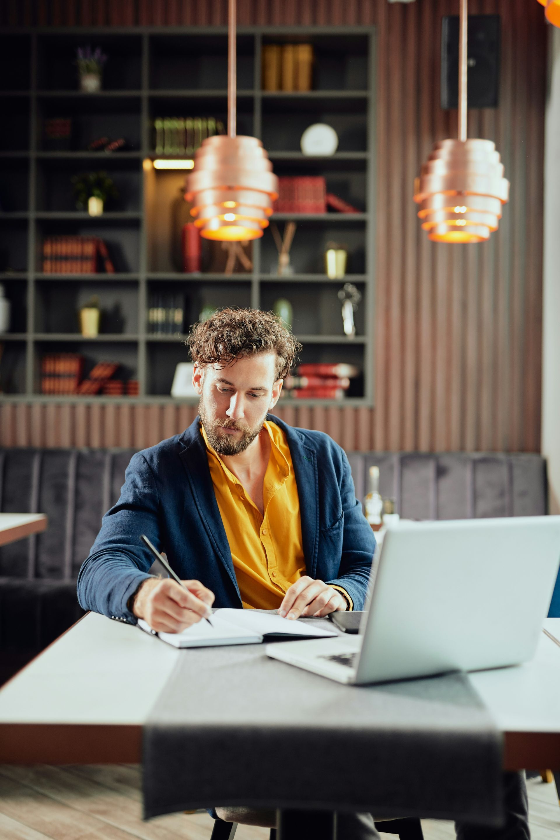 A man in a blue shirt and tie is using a laptop computer.