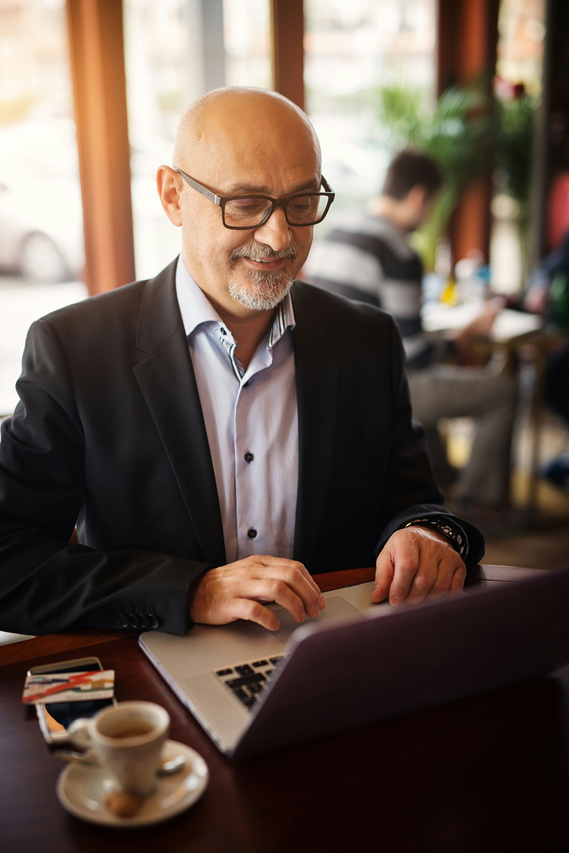 A man in a blue shirt and tie is using a laptop computer.