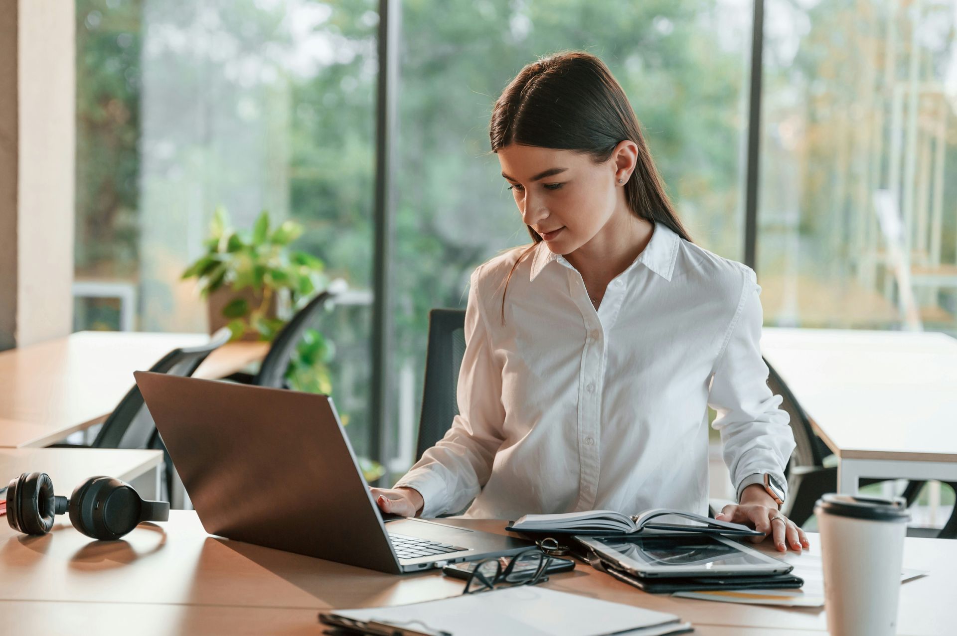 A man in a blue shirt and tie is using a laptop computer.
