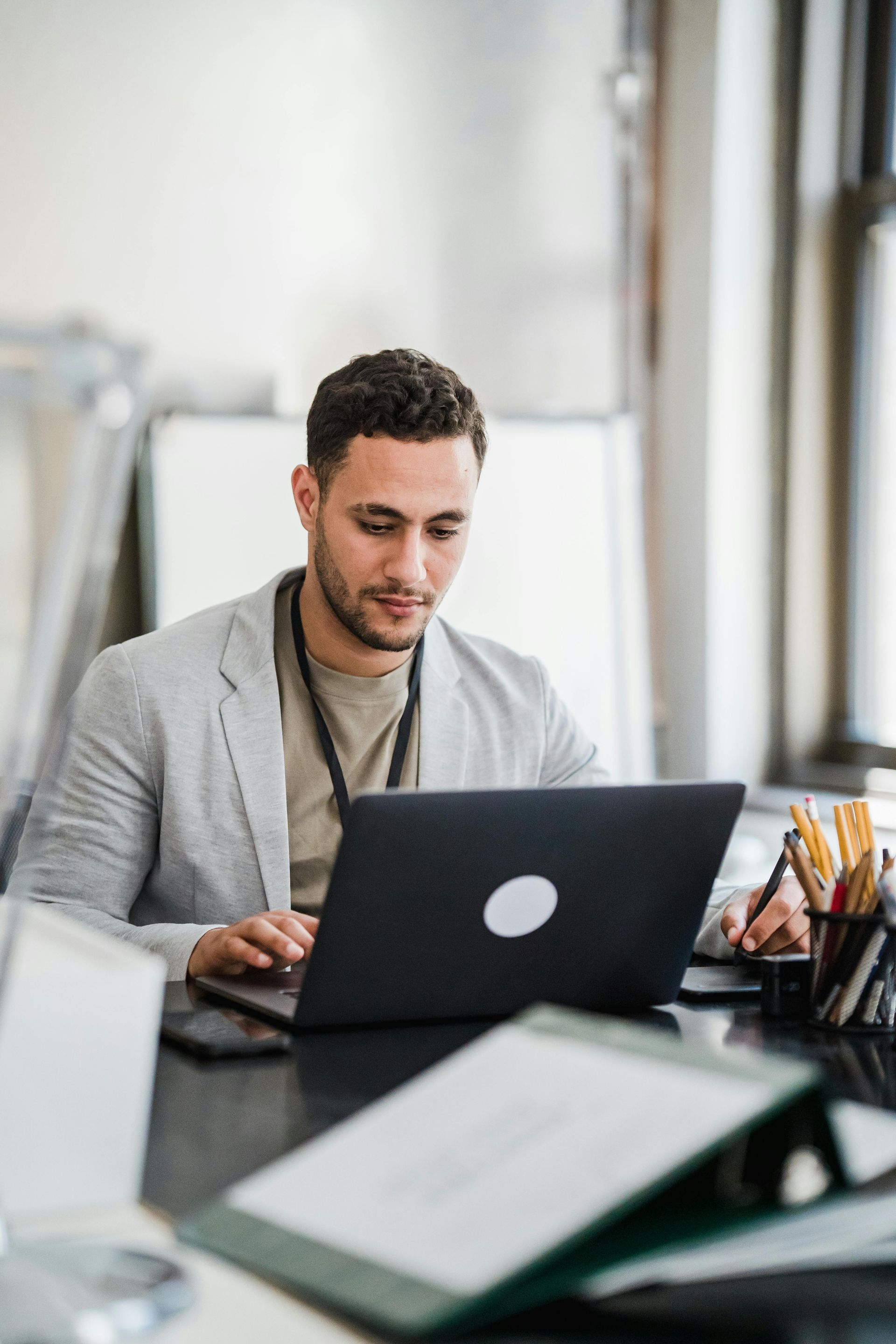 A man in a blue shirt and tie is using a laptop computer.