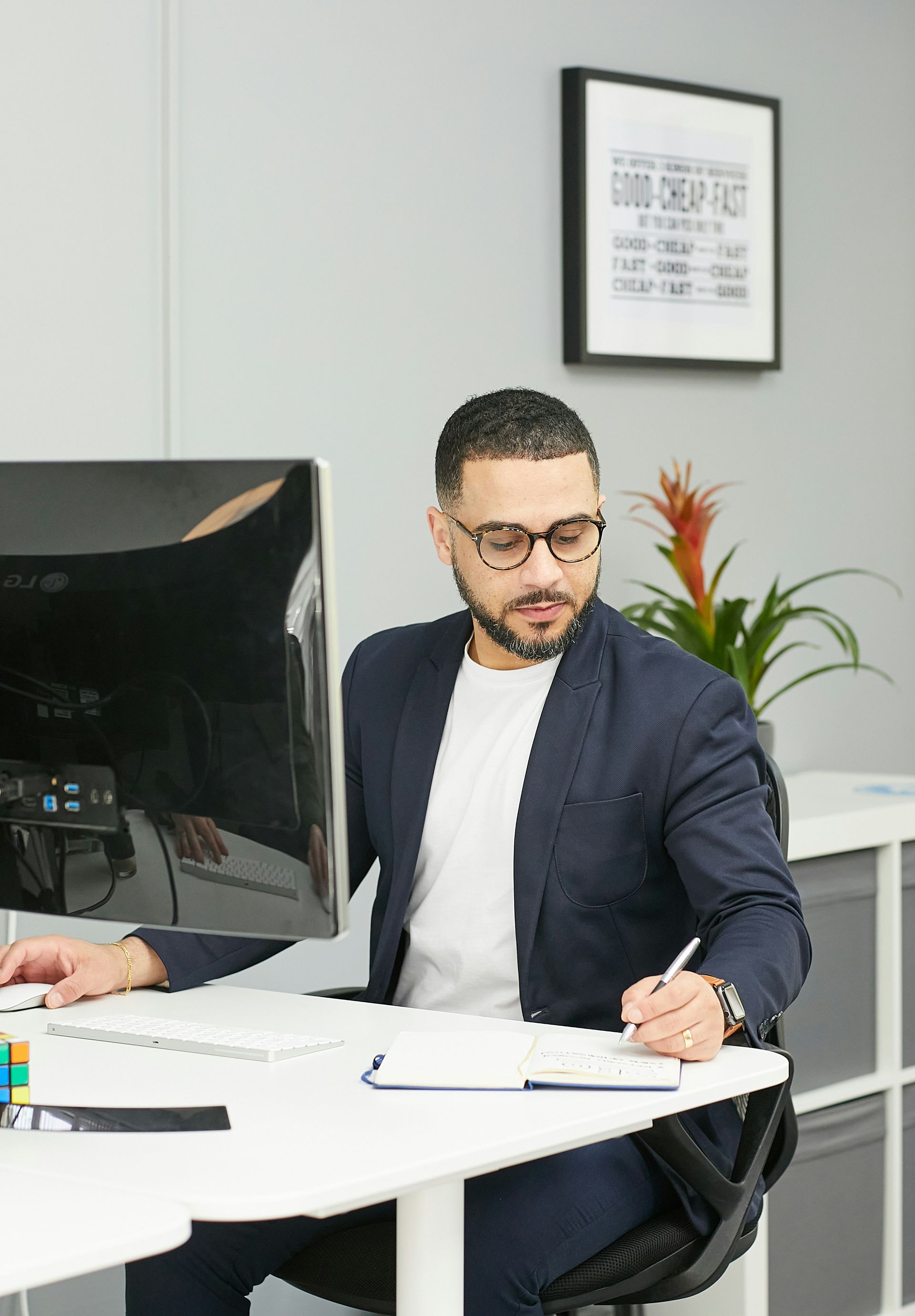 A man in a blue shirt and tie is using a laptop computer.